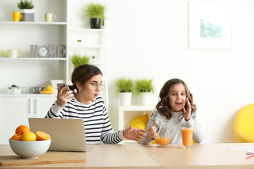 Stressed mother with naughty daughter working at home