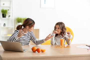 Stressed mother with naughty daughter working at home