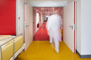 Krankenhaus mit Korridor Bett und Feuerlöscher mit Arzt unscharf in Zentralperspektive