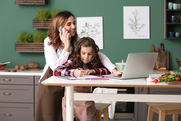Busy mother with daughter working at home
