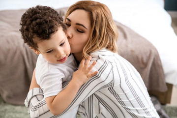 Portrait of happy mother with cute little son at home