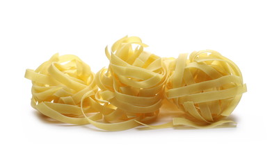 Raw tagliatelle pasta noodles isolated on white background