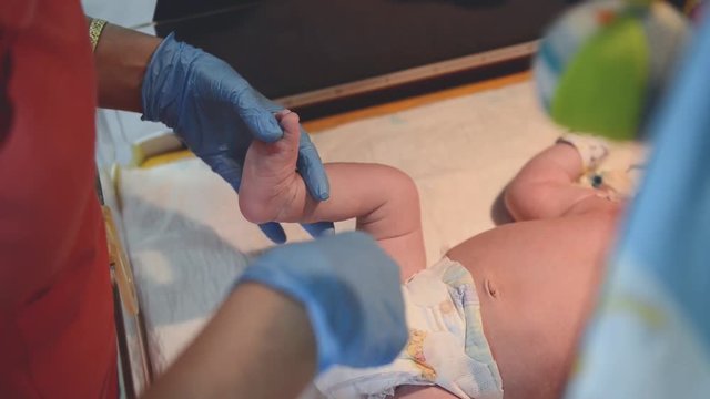 Neonatal Resuscitation. Female doctor examining newborn baby in clinic