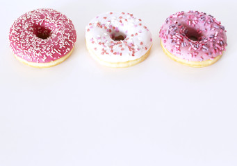 Traditional donuts on white wooden background. Tasty doughnuts with icing and powdered sugar, copy space.