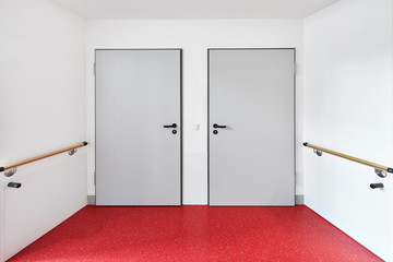 Krankenhaus mit Flur und zwei Türen eines Zimmers mit Box zur Desinfektion und Hygiene auf einer...