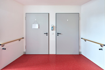Krankenhaus mit Flur und zwei Türen eines Zimmers mit Box zur Desinfektion und Hygiene auf einer Station 