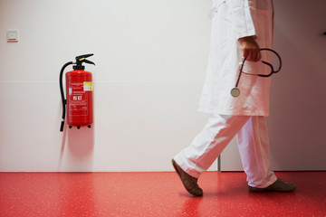 Krankenhaus mit Korridor Feuerlöscher und Frau unscharf in Zentralperspektive