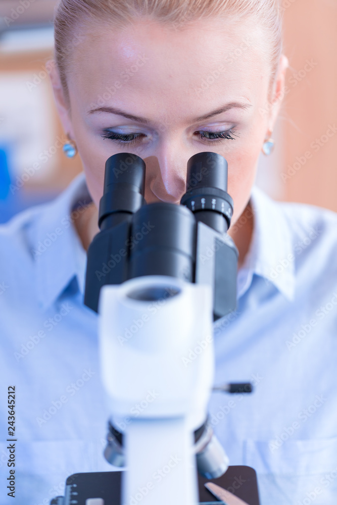 Poster girl with a slide for the microscope university hospital. attractive young scientist looking at the 