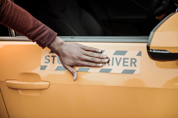 African-American driving instructor showing his student orange car