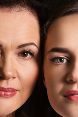 Portrait of young woman with her mother on dark background, closeup