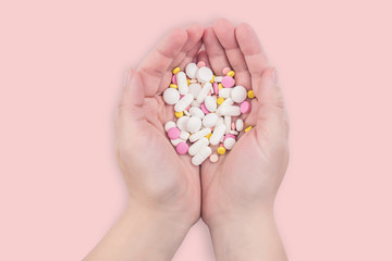Female hands full of colorful medicines,pills, vitamins or supplements. The concept of a healthy and unhealthy lifestyle