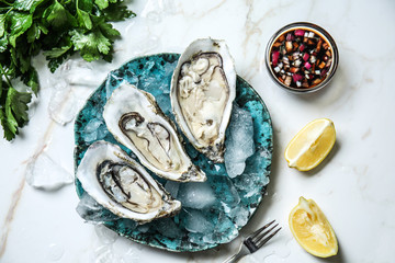 Plate with tasty cold oysters on light table