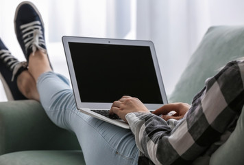 Woman working on modern laptop at home
