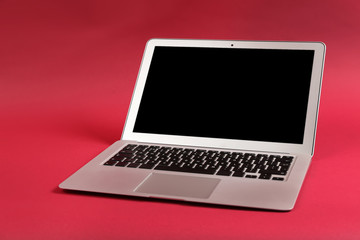 Modern laptop on color background