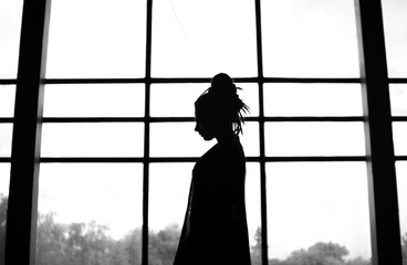 silhouette of girl in window - Powered by Adobe