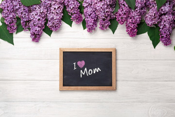 A bouquet of lilacs with chalk board on white boards . Mother's day