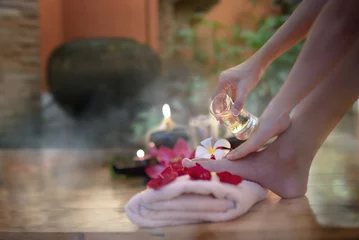 Poster Closeup of hand female holding oil glass salon on feet pedicure procedure. Female legs on decoration the flowers towels, relax and feel comfortable zone spa therapy and treatment © ID_Anuphon