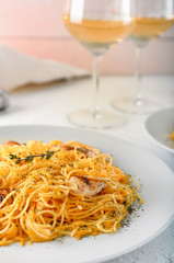 Plate with tasty pasta and chicken on table