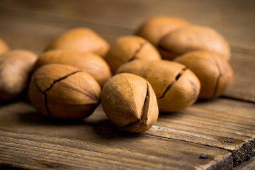 Delicious pecan nuts on the rustic wooden background. Selective focus. Shallow depth of field.