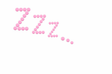 Pink pills in Z shape on the white background. Sleeping pills, hypnotic drugs, sedative. Insomnia. Psychology.