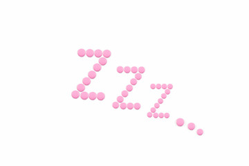 Pink pills in Z shape on the white background. Sleeping pills, hypnotic drugs, sedative. Insomnia. Psychology.