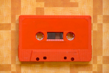 An orange cassette tape on an original background