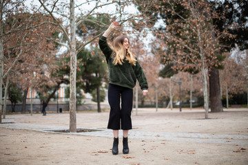 Fototapeta premium Happy young woman jumping and enjoying with injured arm in the park
