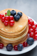 Stack of pancakes with blueberry and fresh berry.