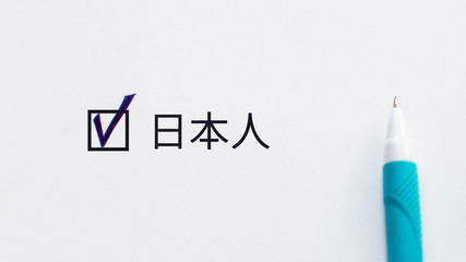 Japanese person (translation from Japanese)  - checkbox with a tick on white paper with blue pen. Checklist concept.