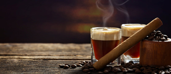 Espresso and cigar on dark wooden table - 243651894
