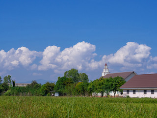 Christian church at green countryside meadow in Thailand.