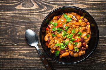 Chili con carne from meat and vegetables on wooden table top vie