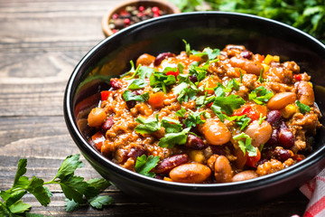 Chili con carne from meat and vegetables on wooden table top vie