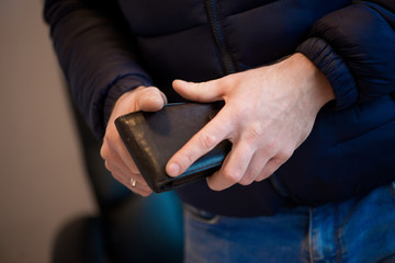 Businessman hands holding black wallet with coins money