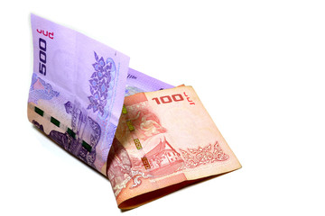 Thai banknotes in the amount of 100 baht and 500 baht. Fold overlapping on a white background.