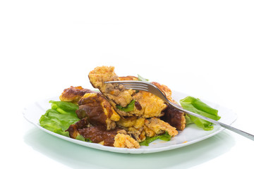 fried omelet with meat and greens in a plate