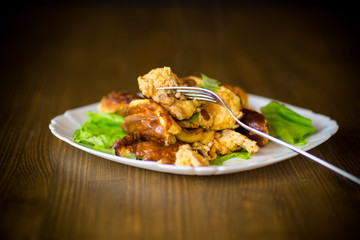fried omelet with meat and greens in a plate