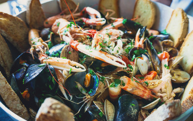 Seafood mussels, fish and shrimps in frying pan served at restaurant authentic food.