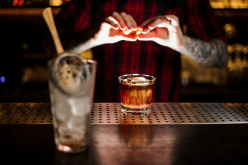 Bartender adding orange zest juice to a Foreign Legion cocktail