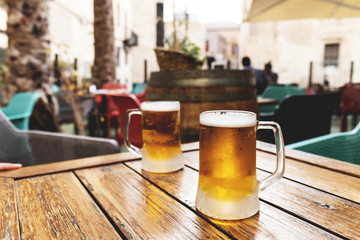 Ice cold inviting beer for two for refreshing the summer heat at the bar table