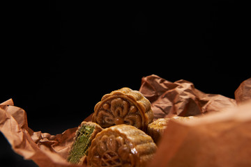 selective focus of traditional chinese mooncakes isolated on black with copy space