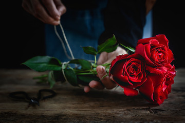Unrecognizable woman making a bouquet of red roses