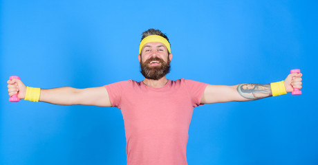 Athlete training with little dumbbell. Man bearded athlete exercising dumbbell. Motivated athlete guy. Sportsman retro outfit training blue background. Athlete on way to stronger body. Healthy habits