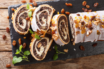 Christmas poppy seed cake partly sliced on wooden table. horizontal top view