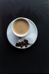 Pojedyncza filiżanka kawy espresso na spodku z ziarnami kawy