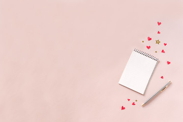 Notebook and pen on pink desk