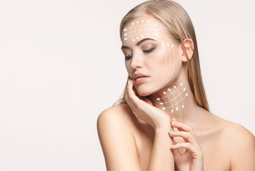 Close-up portrait of young, beautiful and healthy woman with arrows on her face. The spa, surgery,...