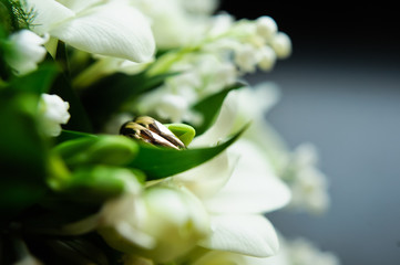 wedding rings on a dark background, Bridal bouquet, tulips