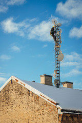Fototapeta na wymiar Telecom worker repairing antenna tower on blue sky background, cellular tower system.