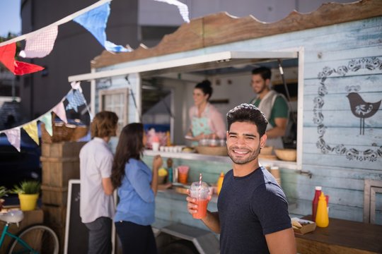Smiling man holding a glass of juice